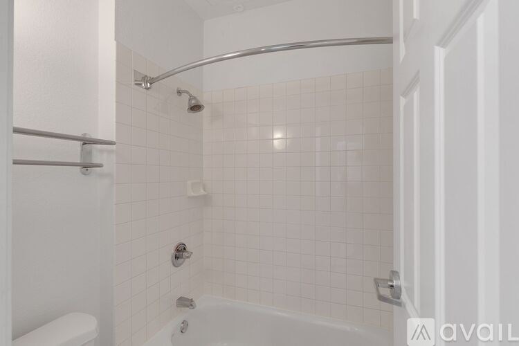 A white bathroom with a shower and a bathtub.