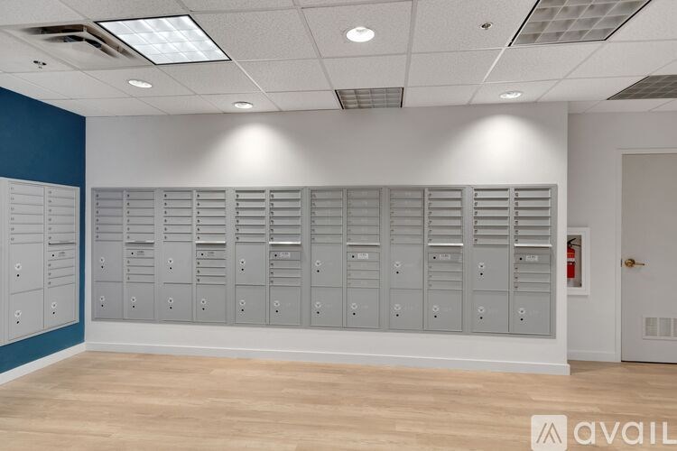 A room with a row of grey lockers against a blue wall.
