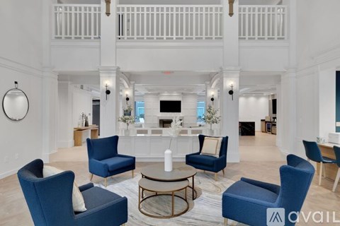 A living room with blue chairs and a white sofa.