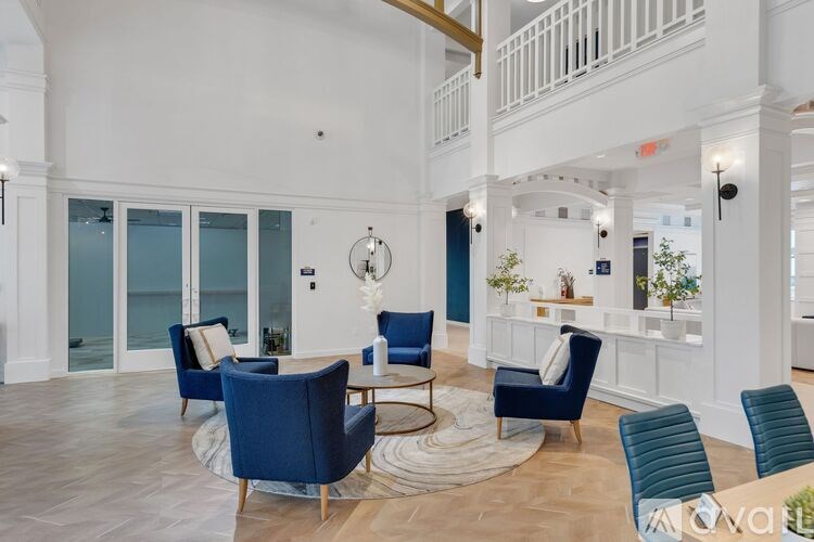 A living room with blue chairs and a white wall.
