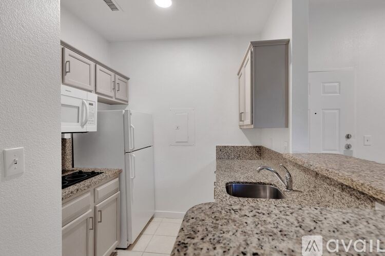 A kitchen with granite countertops and white appliances.