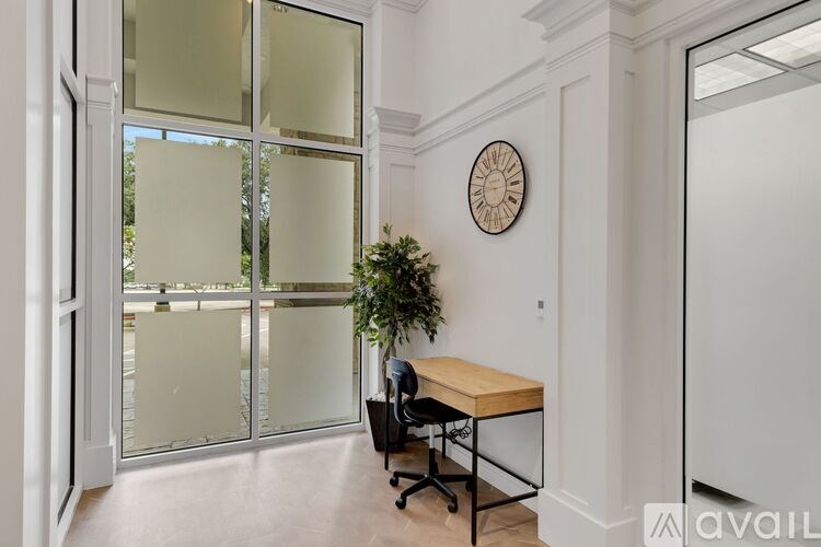 A room with a desk, chair, and a clock on the wall.