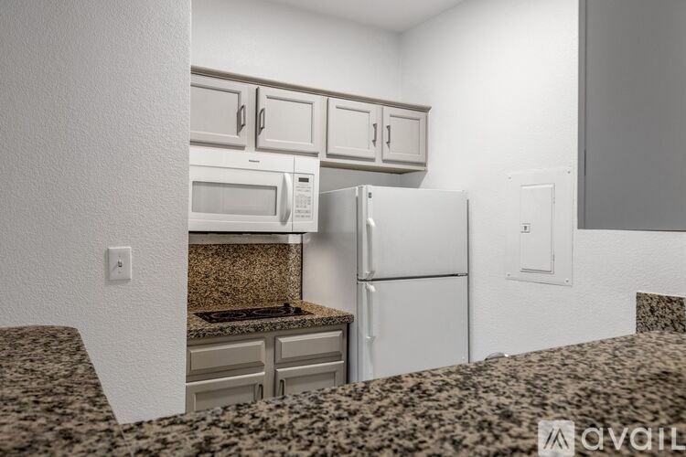 A kitchen with a granite countertop and a refrigerator.