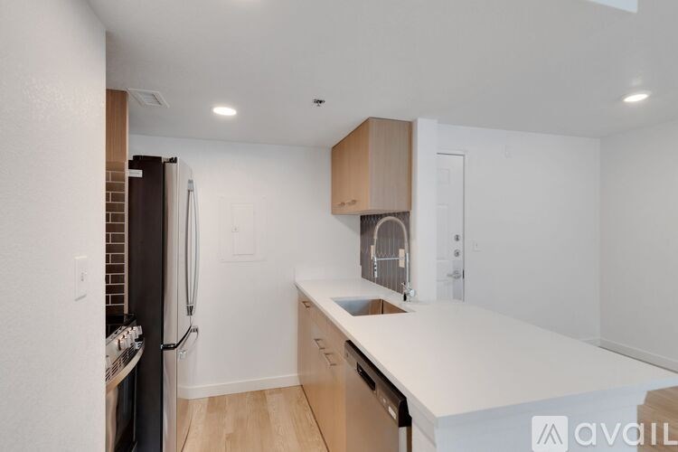 A kitchen with a white countertop and wooden cabinets.