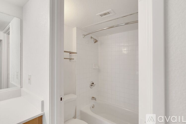 A white bathroom with a tub, toilet, and sink.