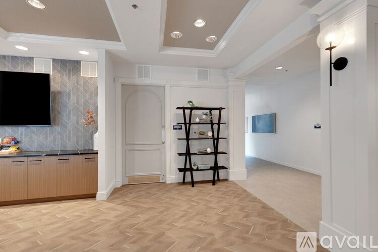 A spacious living room with a television, a cabinet, and a bookshelf.