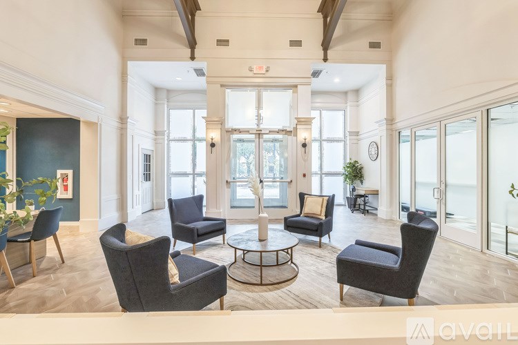 A living room with a grey sofa, a black armchair, a grey armchair, a black chair and a coffee table.
