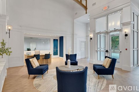 A living room with blue chairs and a white wall.