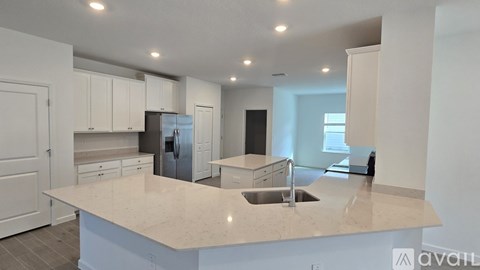 A kitchen with white cabinets and a large island.