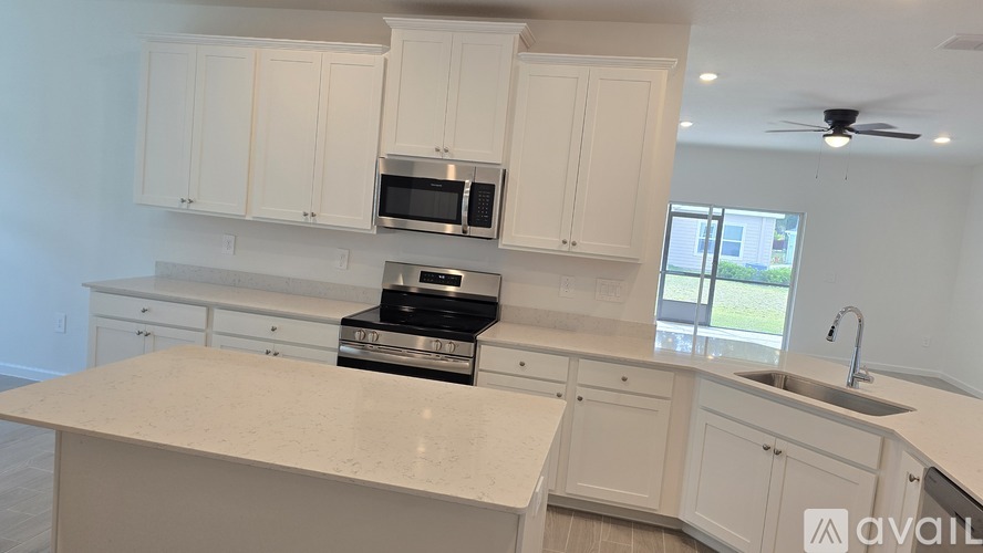 A kitchen with white cabinets and a large island.