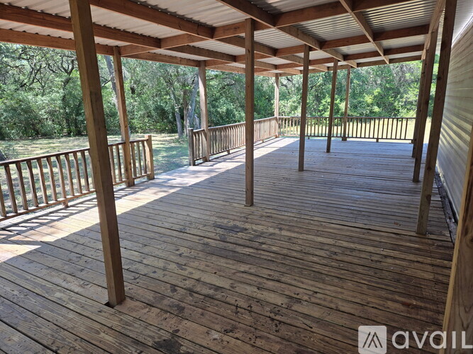 A wooden deck with a metal roof and railings.