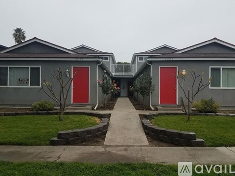 A row of houses with red doors in the front yard.