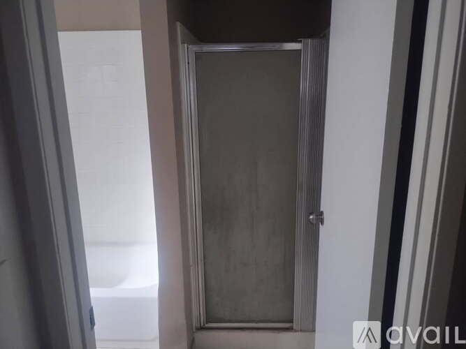 A closed door in a room with a white wall.