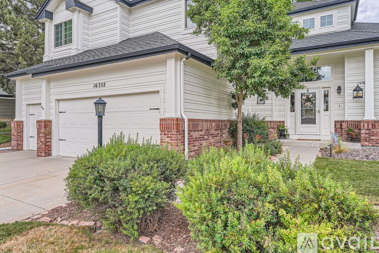 A house with a white garage door and a black lamp post.