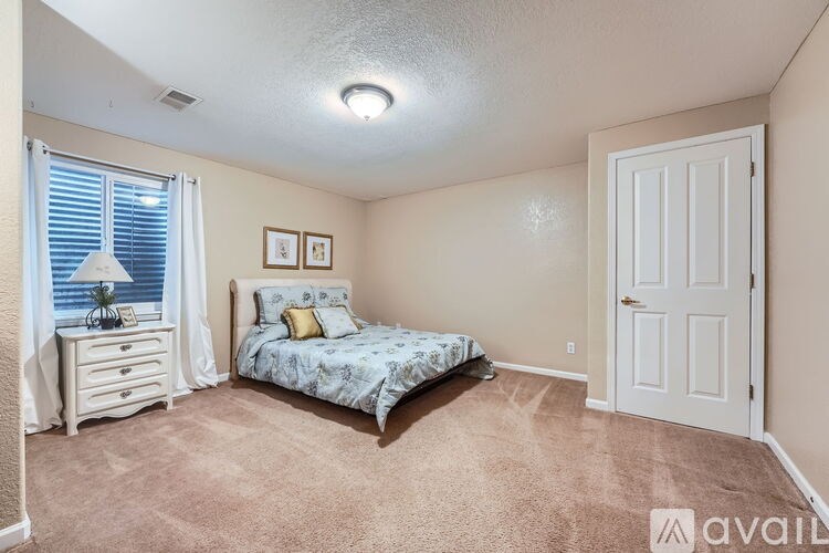 A bedroom with a bed, dresser, and window.