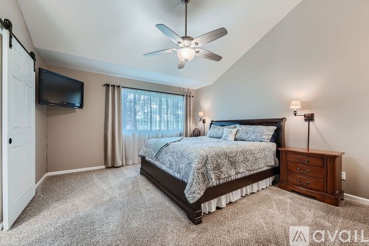 A bedroom with a bed, dresser, and ceiling fan.