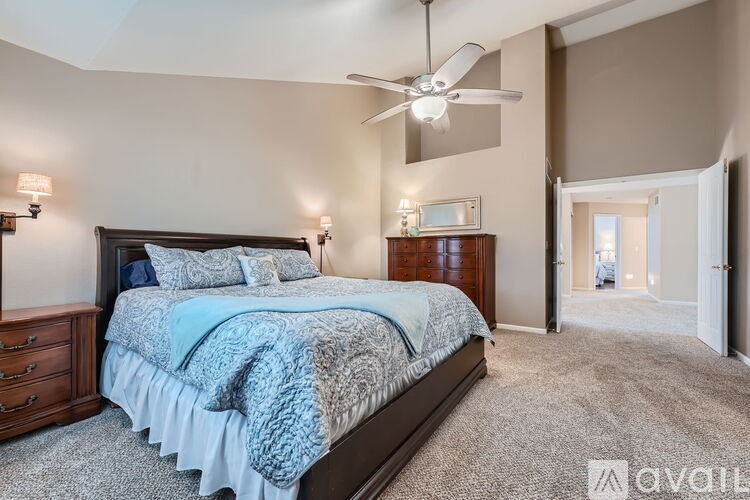 A bedroom with a large bed and a ceiling fan.