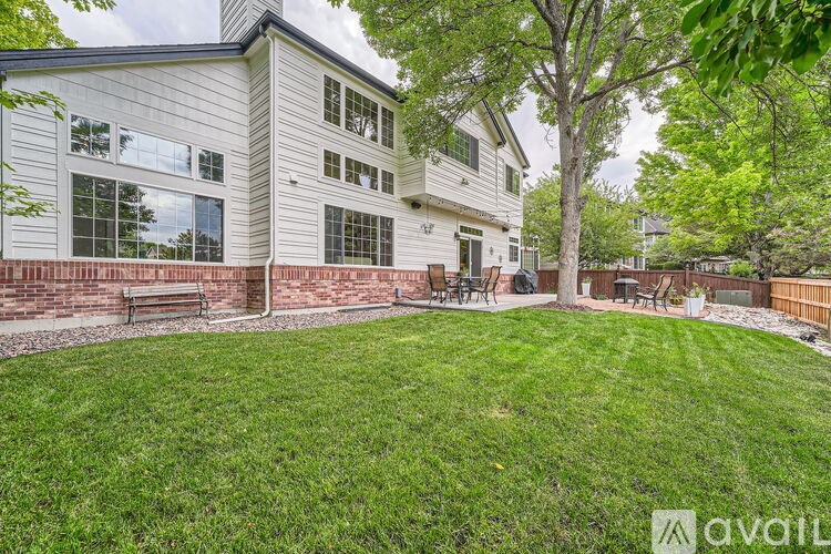 A house with a white exterior and a green lawn in front.