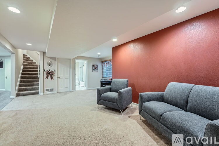 A living room with a grey couch and a grey armchair.