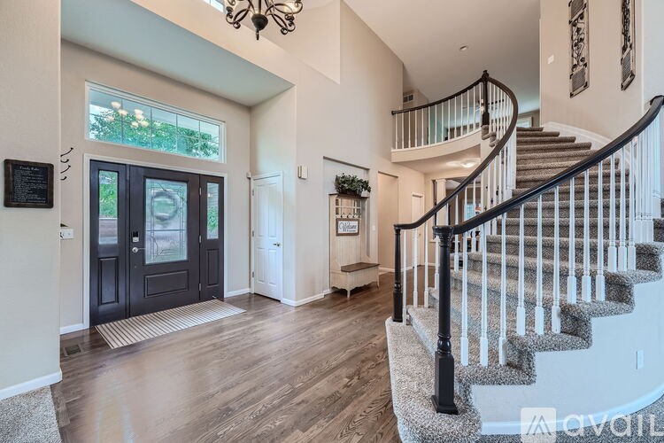 A large, open foyer with a staircase and a chandelier.