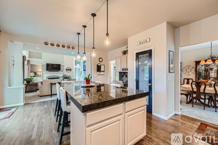 A modern kitchen with a large island and pendant lights.