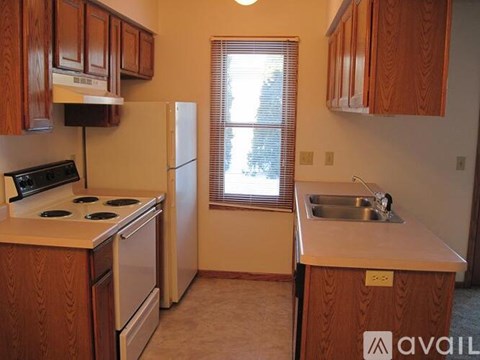 A kitchen with wooden cabinets and a stove top oven.