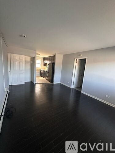 A spacious room with wooden floors and white walls.