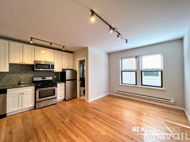 A kitchen with wooden floors and a large window.