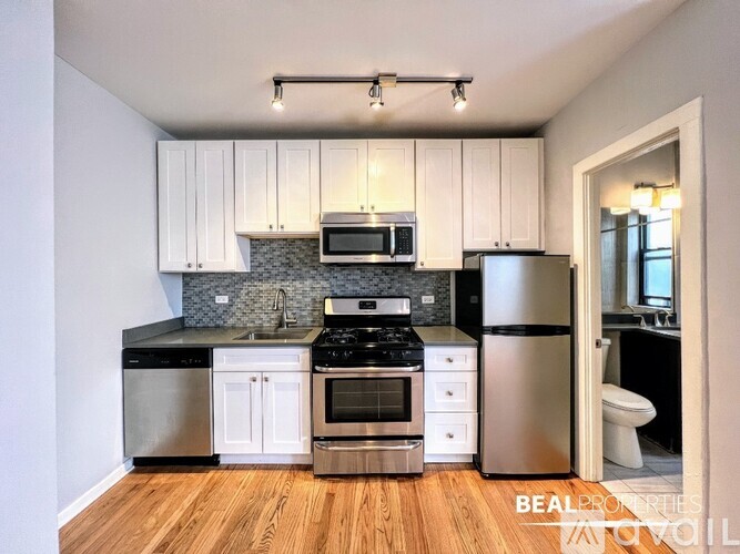 A kitchen with white cabinets and stainless steel appliances.