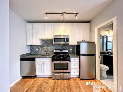 A kitchen with white cabinets and stainless steel appliances.
