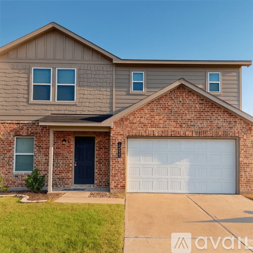 A two-story house with a garage door and a brick wall.