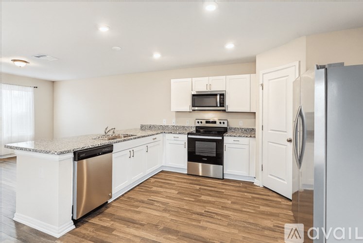 A kitchen with white cabinets and stainless steel appliances.