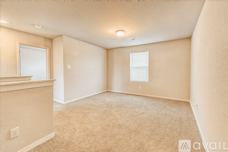 A room with a carpeted floor and a window.