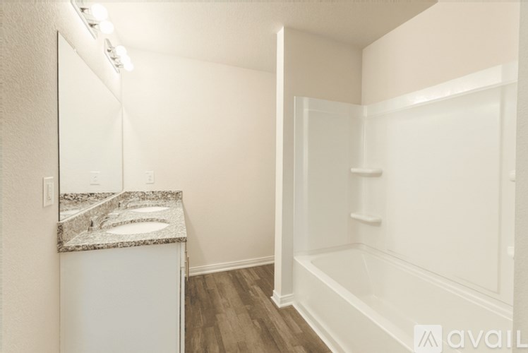 A bathroom with a sink, mirror, and bathtub.