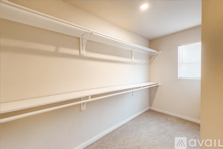 A room with a window and a carpeted floor.