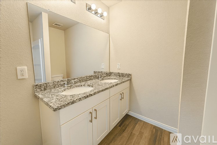 A bathroom with a granite countertop and white cabinets.