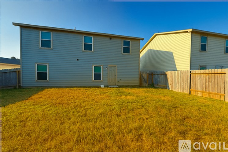 A house with a fence and a grassy yard.
