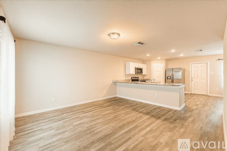 A spacious room with wooden flooring and a reception desk.
