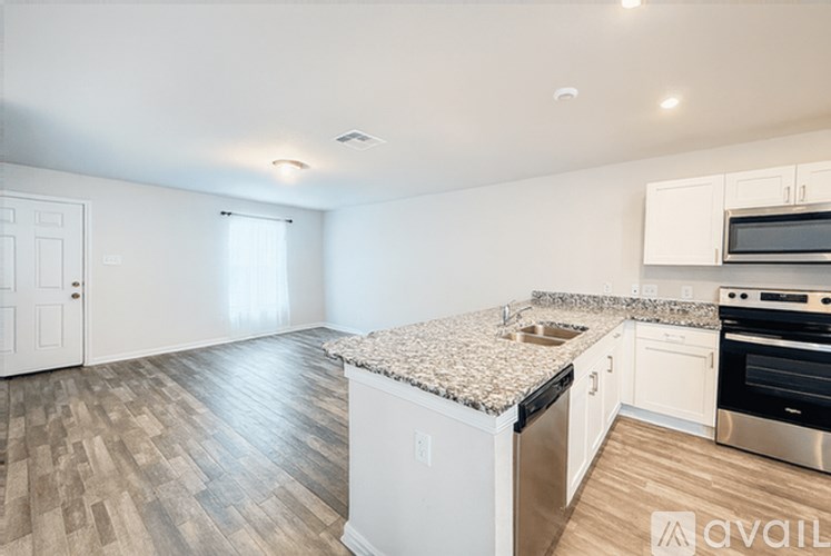 A kitchen with a granite countertop and stainless steel appliances.