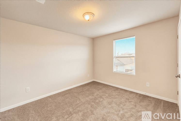 A room with a carpeted floor and a window showing a building outside.