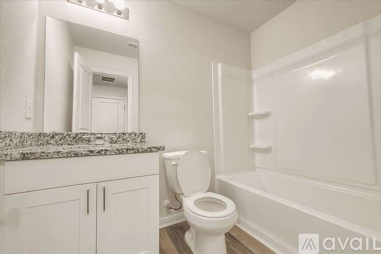 A white bathroom with a toilet, sink, and bathtub.