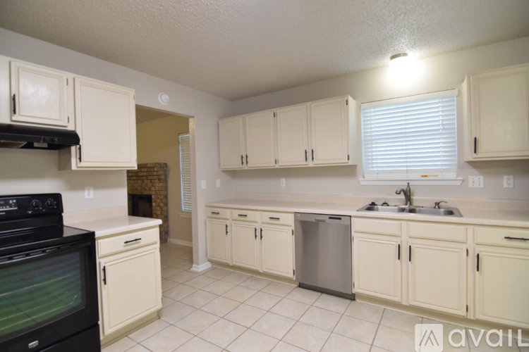A kitchen with white cabinets and a black stove top oven.