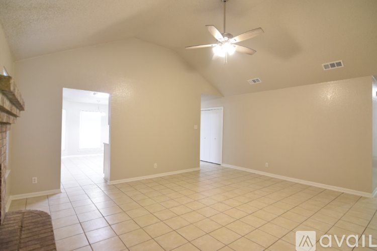 A spacious room with a ceiling fan and tiled flooring.