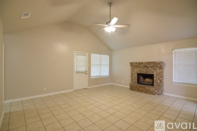 A living room with a fireplace and a ceiling fan.