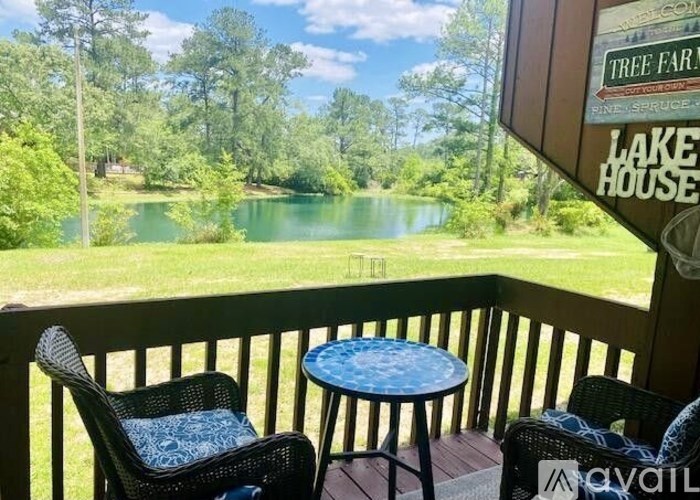 A balcony with a view of a lake and trees.