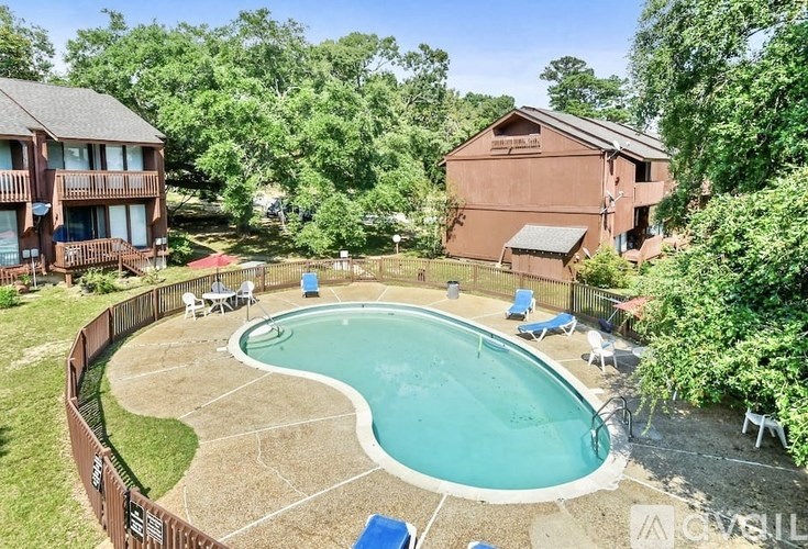 A backyard with a pool and a house.