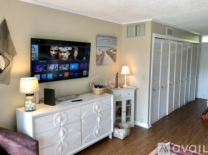 A living room with a television, a cabinet, and a chair.