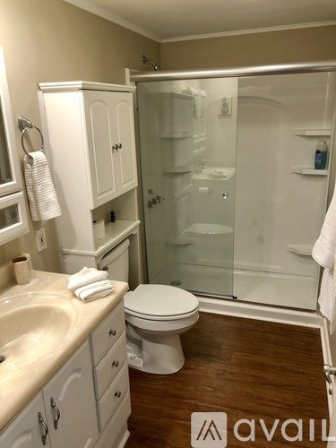 A bathroom with a toilet, sink, and shower.