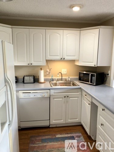 A kitchen with white cabinets and appliances.