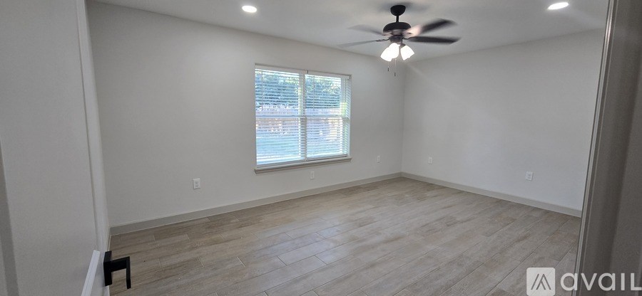 A room with a ceiling fan and a window.